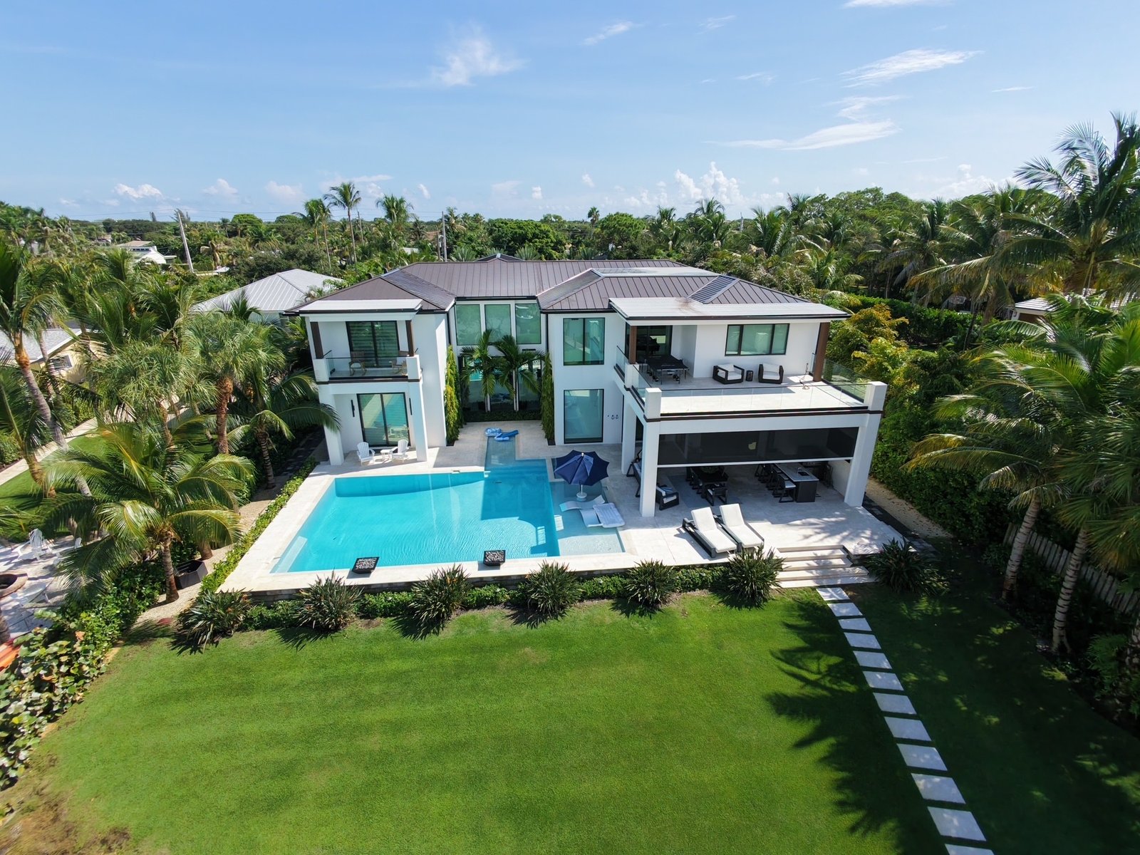 Aerial view of the house, pool and lawn from the water side