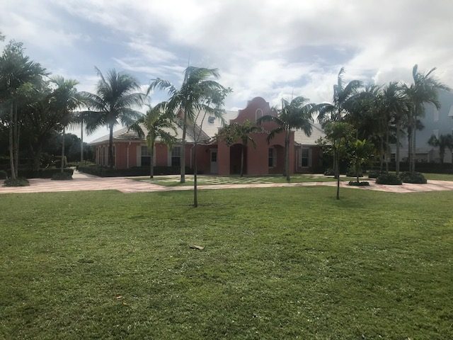 Church building with arched entry and palm trees, Jupiter Florida